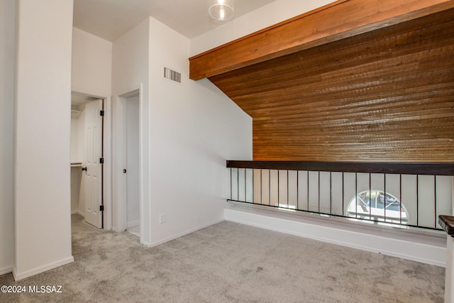 bonus room with lofted ceiling with beams and light colored carpet