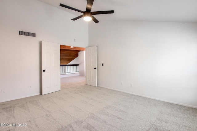 spare room with high vaulted ceiling, light carpet, and ceiling fan