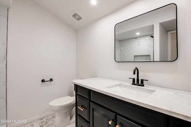 bathroom featuring vanity, walk in shower, and toilet