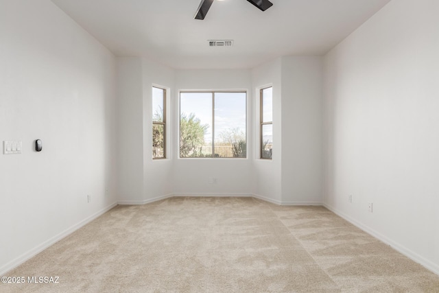 empty room featuring ceiling fan and light colored carpet