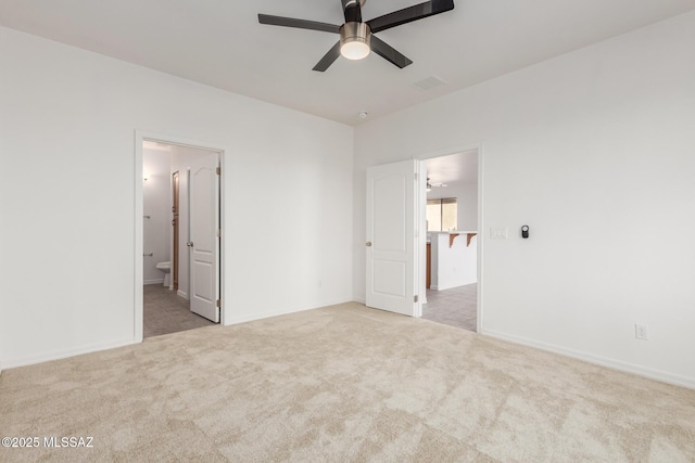 unfurnished bedroom featuring ceiling fan, light carpet, and ensuite bath