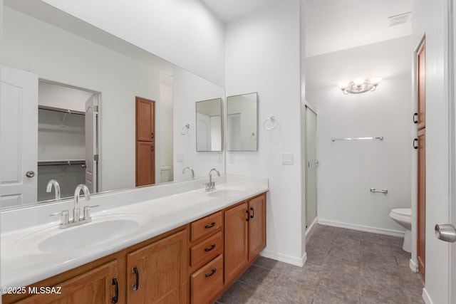 bathroom featuring vanity, an enclosed shower, and toilet