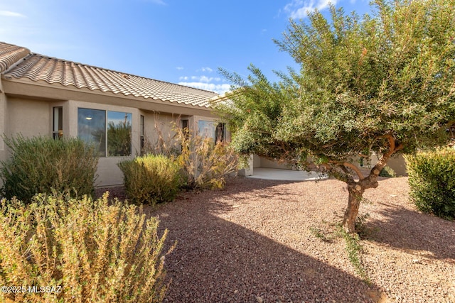 view of property exterior with a patio area