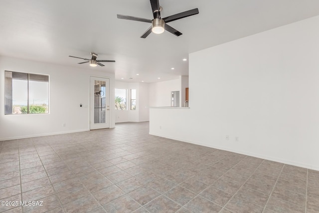 tiled empty room featuring ceiling fan