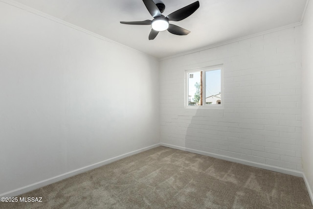 empty room with ceiling fan, ornamental molding, brick wall, and carpet flooring