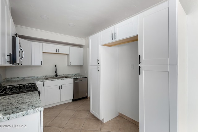 kitchen featuring white cabinetry, sink, stainless steel appliances, and light tile patterned flooring