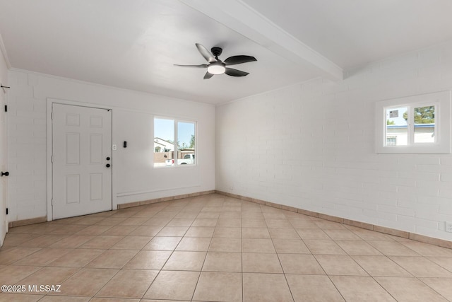 tiled spare room featuring beamed ceiling, brick wall, and ceiling fan