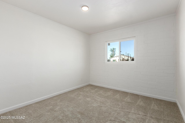 empty room featuring crown molding, brick wall, and carpet flooring