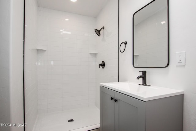 bathroom with vanity and tiled shower