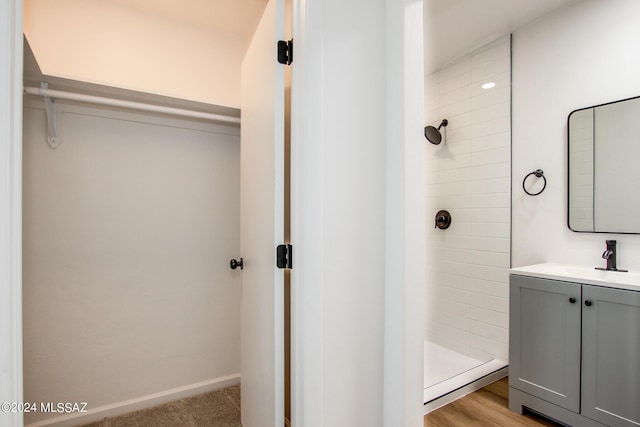 bathroom featuring tiled shower and vanity