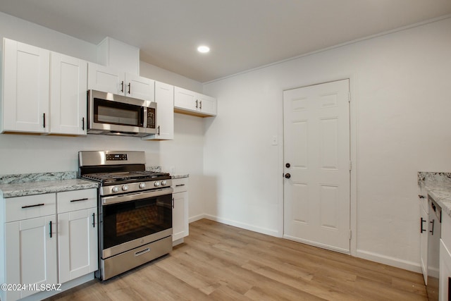 kitchen with stainless steel appliances, light stone countertops, light hardwood / wood-style flooring, and white cabinets