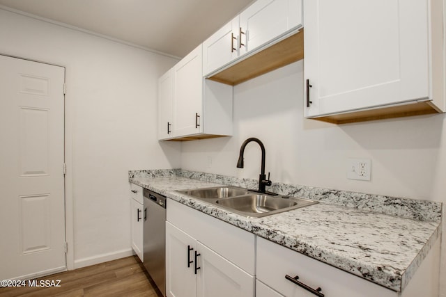 kitchen with sink, light stone counters, dishwasher, light hardwood / wood-style floors, and white cabinets