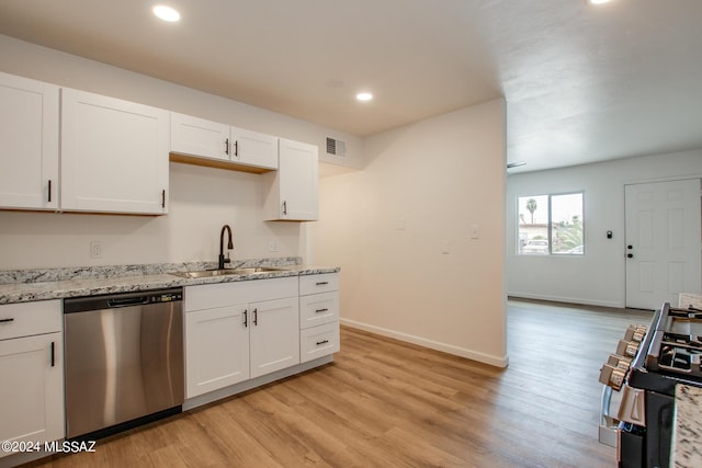 kitchen featuring sink, stainless steel dishwasher, white cabinets, and light hardwood / wood-style floors