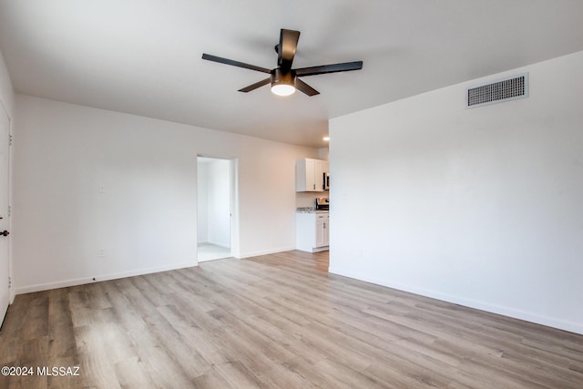 spare room with ceiling fan and light wood-type flooring