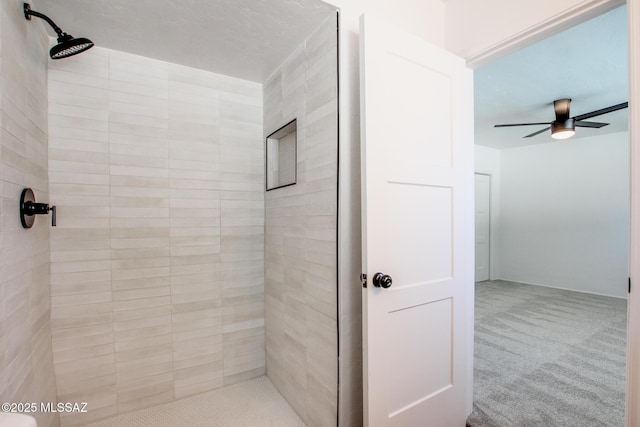 bathroom with ceiling fan and tiled shower