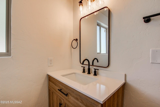 bathroom with a textured wall and vanity