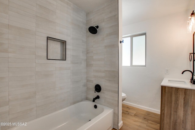 full bath with baseboards, toilet, shower / bathtub combination, wood finished floors, and vanity