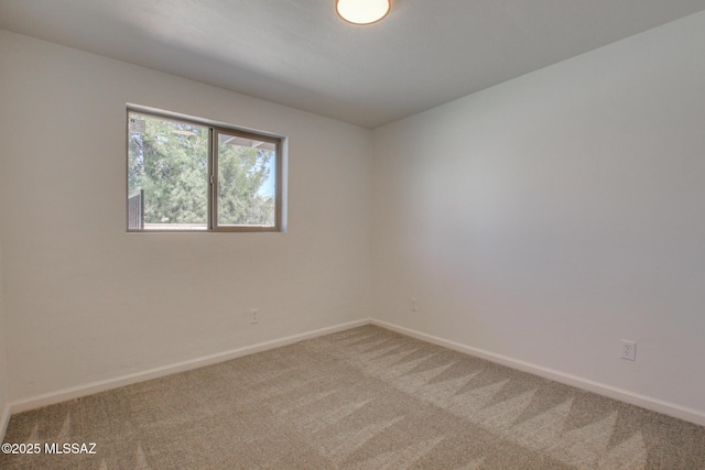 spare room with carpet and baseboards