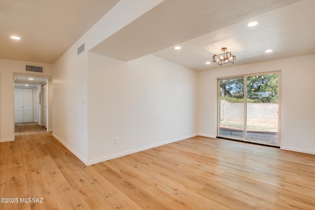 unfurnished room featuring light wood-type flooring, baseboards, and visible vents