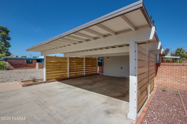 view of side of home with a carport, fence, and driveway