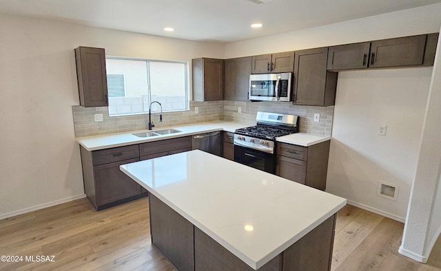 kitchen with sink, decorative backsplash, stainless steel appliances, and a kitchen island