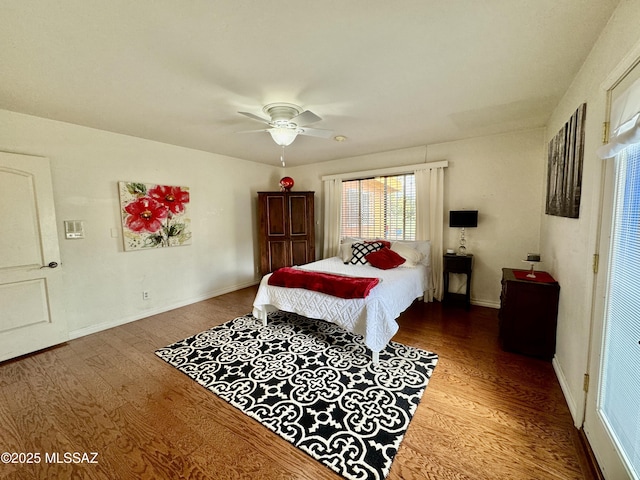 bedroom with a ceiling fan, baseboards, and wood finished floors