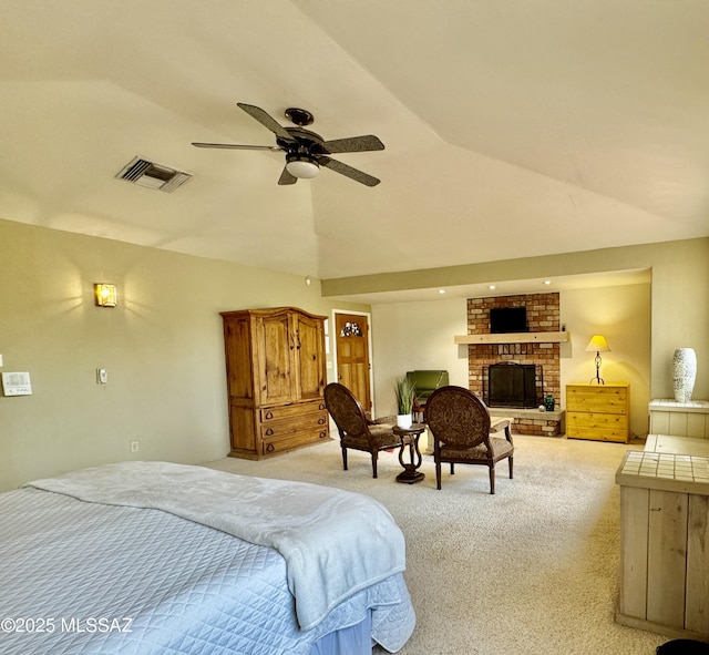 bedroom with light carpet, a fireplace, a ceiling fan, vaulted ceiling, and visible vents