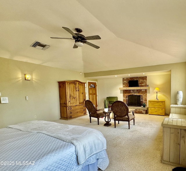 bedroom featuring ceiling fan, lofted ceiling, light carpet, a fireplace, and visible vents