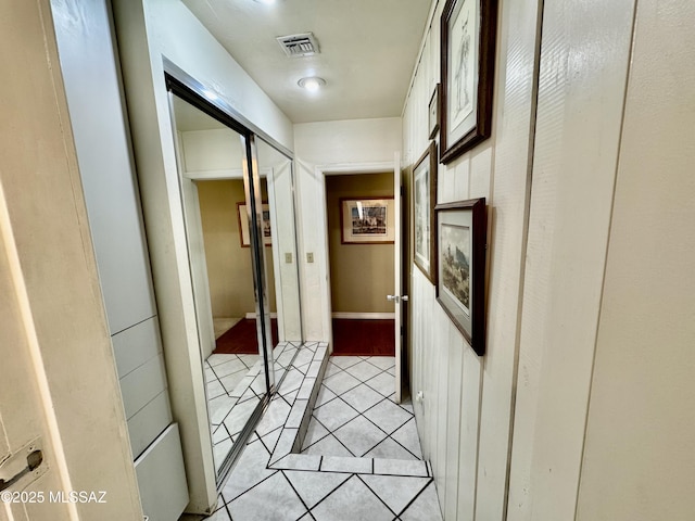 hall featuring visible vents and light tile patterned flooring
