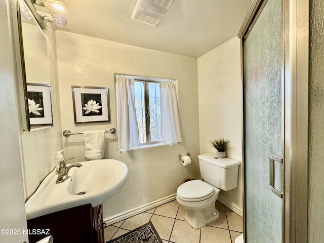 bathroom with toilet, visible vents, baseboards, vanity, and tile patterned floors