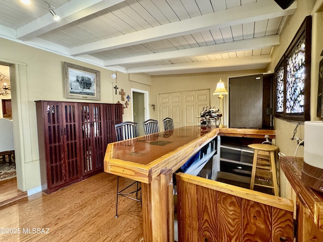 dining room featuring wood ceiling, beam ceiling, and wood finished floors