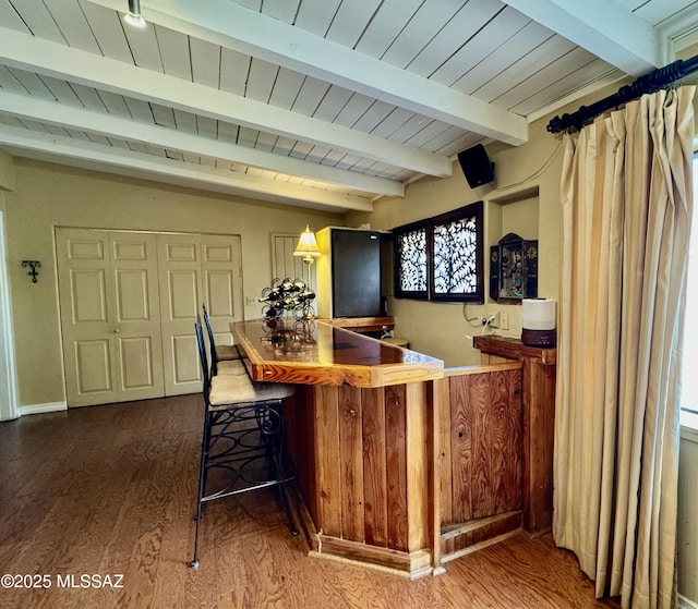 bar with indoor bar, beamed ceiling, wood finished floors, and wood ceiling