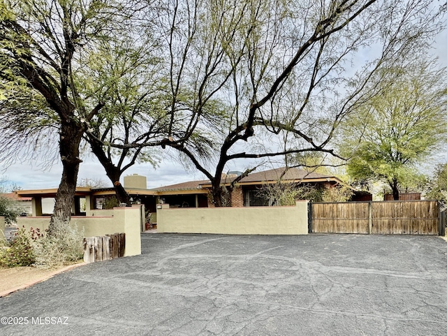 single story home featuring a fenced front yard, a gate, and stucco siding