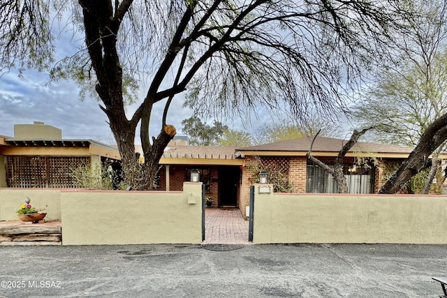 single story home with brick siding and a fenced front yard