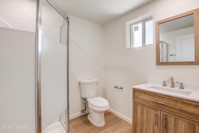 bathroom with vanity, wood-type flooring, an enclosed shower, and toilet