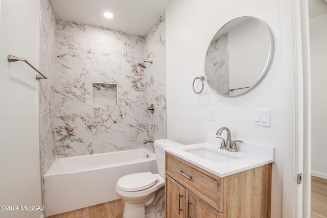 full bathroom featuring hardwood / wood-style flooring, vanity, toilet, and tiled shower / bath combo