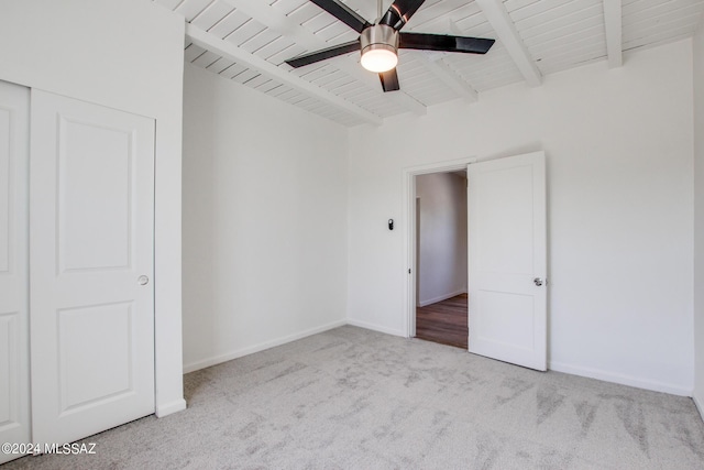 carpeted spare room with beamed ceiling, wooden ceiling, and ceiling fan