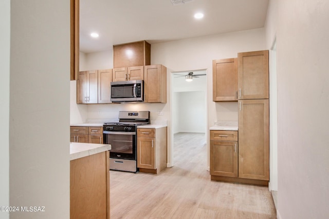 kitchen with light hardwood / wood-style flooring, light brown cabinets, ceiling fan, and appliances with stainless steel finishes