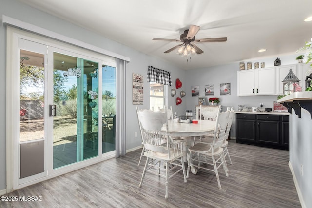 dining area with wood-type flooring and ceiling fan