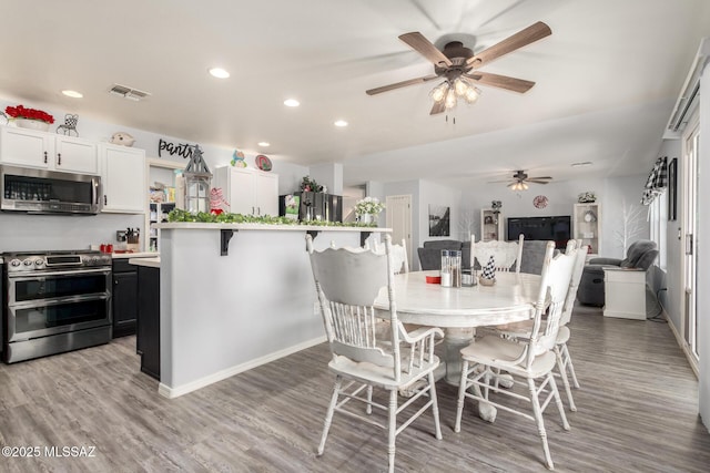 dining space with ceiling fan and light hardwood / wood-style floors