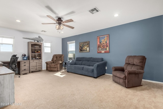 living room with light carpet, ceiling fan, and a healthy amount of sunlight