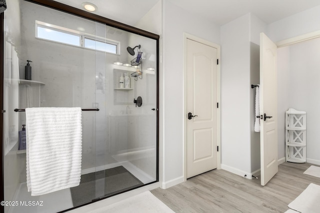 bathroom featuring wood-type flooring and a shower with shower door