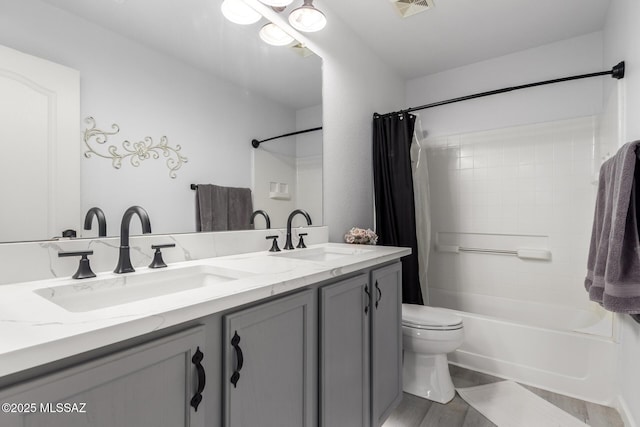 full bathroom featuring vanity, wood-type flooring, shower / bath combination with curtain, and toilet