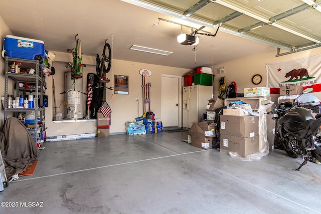 garage featuring a garage door opener, white refrigerator with ice dispenser, and gas water heater