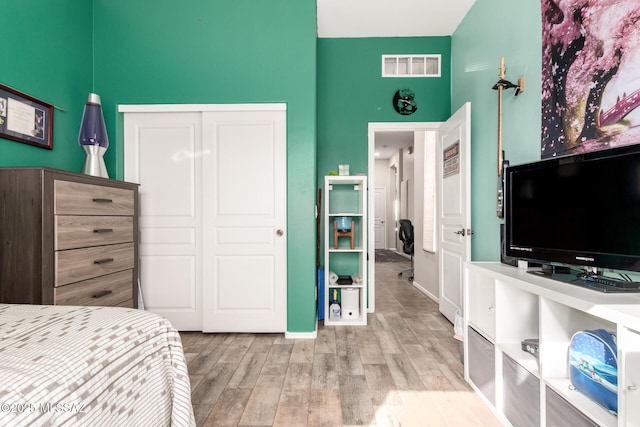 bedroom with light wood-type flooring and a closet