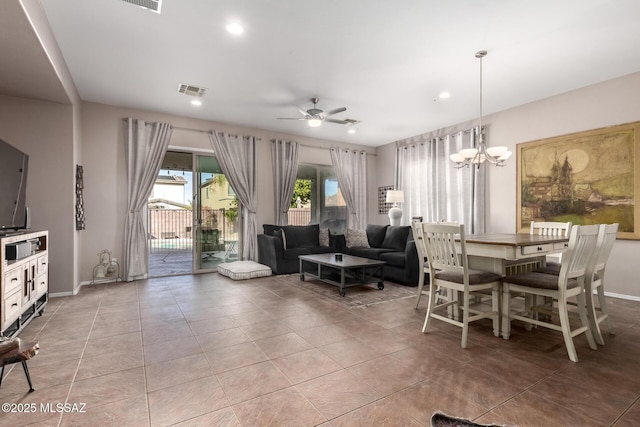 dining room with light tile patterned floors and ceiling fan with notable chandelier