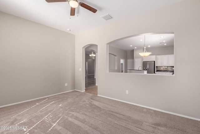 unfurnished living room with light carpet and ceiling fan