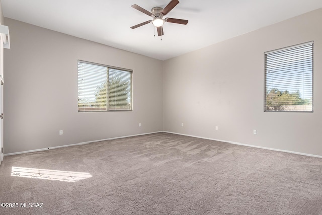 carpeted spare room featuring ceiling fan