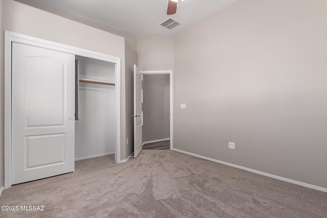 unfurnished bedroom featuring light colored carpet, ceiling fan, and a closet