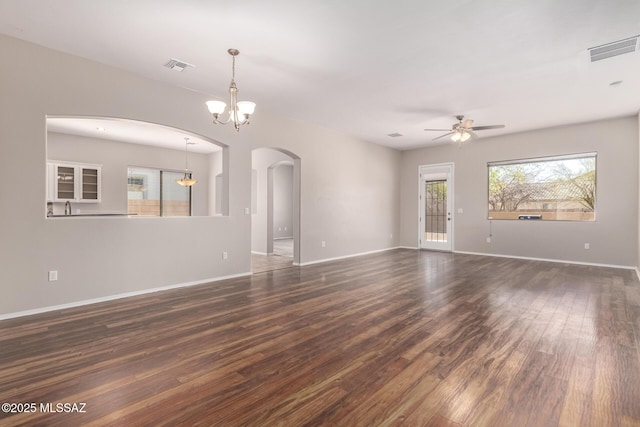 unfurnished room featuring dark wood-type flooring and ceiling fan with notable chandelier